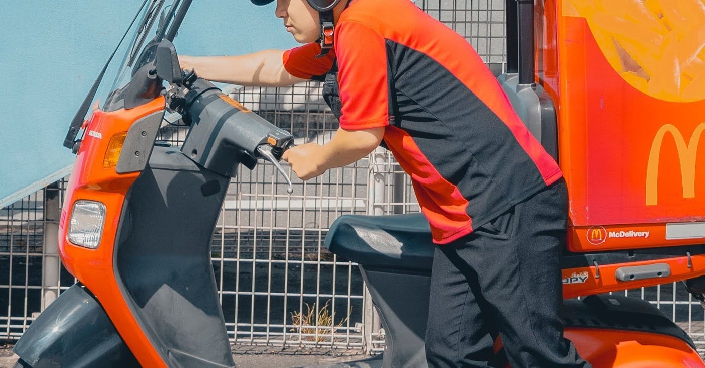 A delivery rider mounting his scooter — the frontline workforce TrabajaYa hires